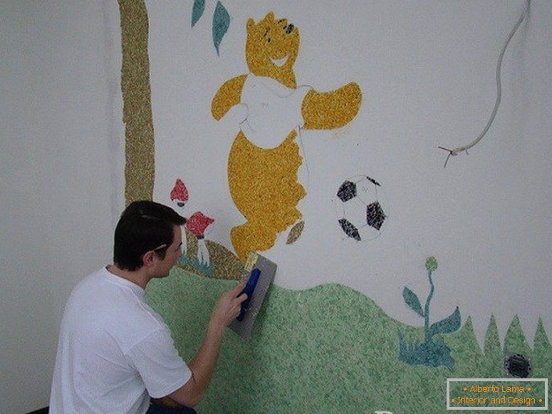 El hombre dibuja Winnie the Pooh en la pared en el cuarto de niños