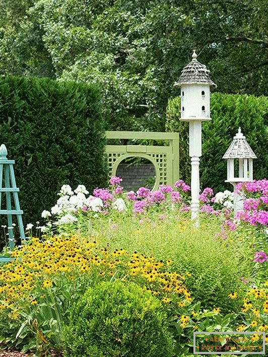 Jardín con una casa para pájaros y otras decoraciones