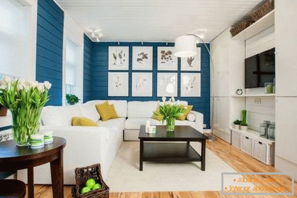 Sofá blanco en el interior con papel pintado azul y piso de madera