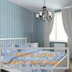 Dormitorio azul con cortinas blancas