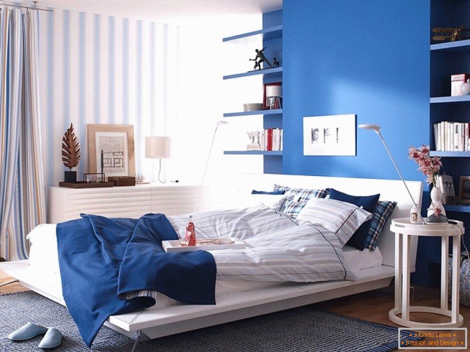 Pared azul en el dormitorio combinado con papel pintado a rayas