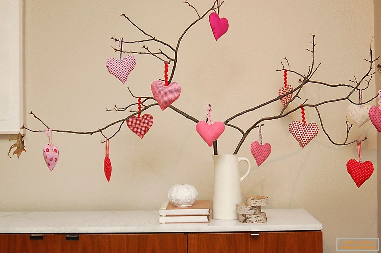 Ramas de árboles decorados con corazones hechos de fieltro