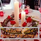 Decoración de una mesa con velas y pétalos de rosa