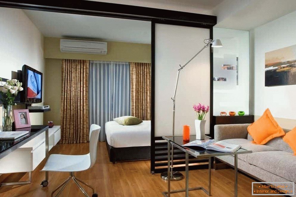 Dormitorio y sala de estar en una habitación separados por una partición semitransparente