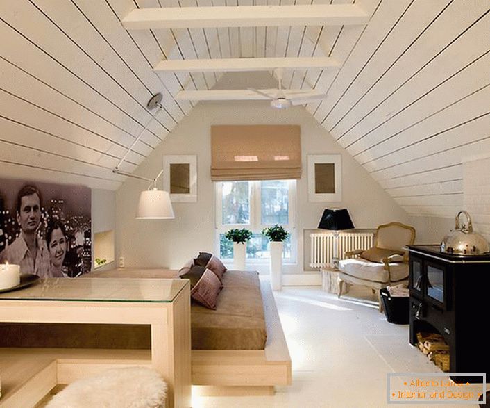 El ático está decorado en un estilo minimalista con notas de chalet. El espíritu del estilo del pueblo hace que el dormitorio sea especial y memorable.