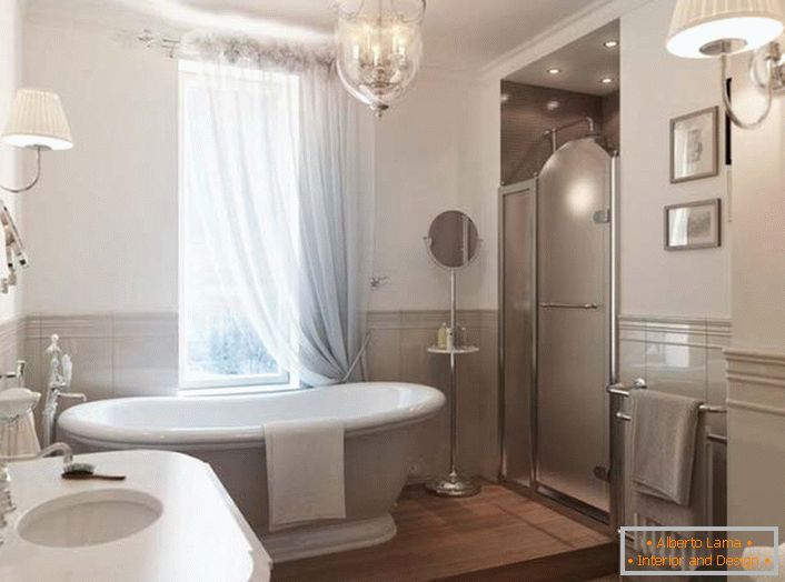 Un gran baño de cerámica blanca se convierte en un elemento destacado del interior de la habitación. La ventana está cubierta con una cortina que cae traslúcida hecha de tela natural, que corresponde plenamente al estilo del Art Nouveau.