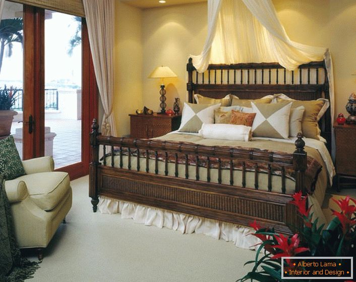 Cama de lujo en el dormitorio en el estilo del eclecticismo. Baldaquino sobre la cama, cortinas claras en las puertas que conducen a la veranda hacen que la habitación sea acogedora y romántica. 