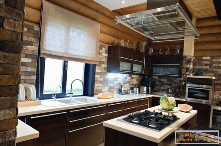 El acabado hecho de ladrillos se ve orgánicamente en el fondo del marco de madera. La combinación exclusiva completa con muebles y electrodomésticos modernos es una solución ventajosa para decorar la cocina en una casa de pueblo.