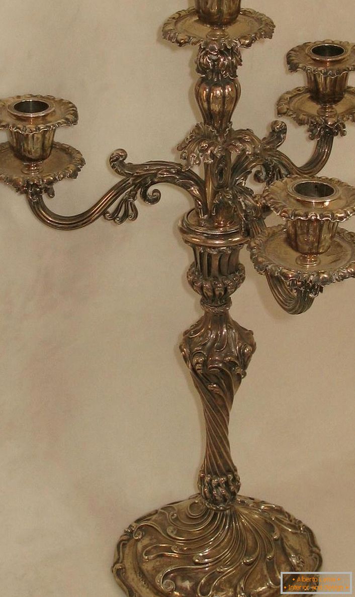 Un elegante candelabro hecho de cobre para cuatro velas para un salón campestre.