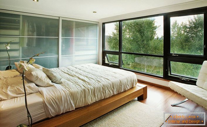 Una cama baja hecha de madera encaja armoniosamente en el interior de la habitación en el estilo Art Nouveau.