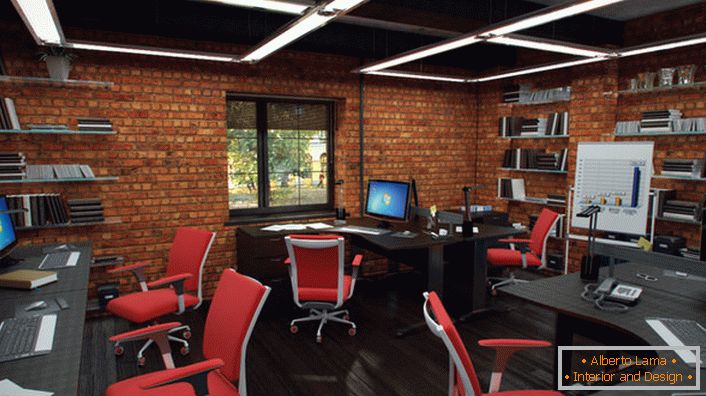 Las sillas rojas en la oficina en el estilo loft se ven de manera orgánica y creativa. El interior es tan funcional como sea posible.