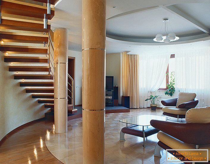 Un salón amplio y luminoso debajo de una escalera en un apartamento de dos niveles. 