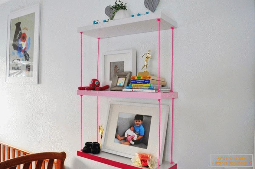 Una estantería para una habitación para niños con cuerdas rosas