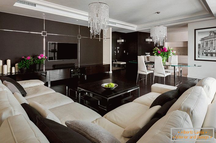 En el interior de la sala de estar, compiten dos colores: blanco y marrón. El diseñador resuelve el problema pintando, candelabros y flores.