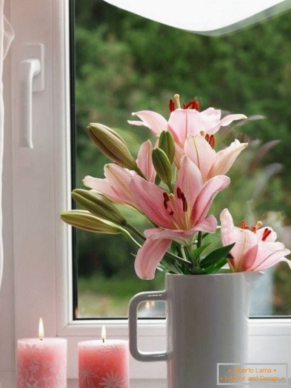 Velas y flores en el alféizar de la ventana
