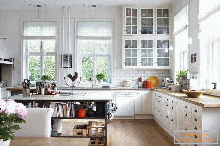 Una cocina espaciosa en el estilo escandinavo debe ser lo más liviana posible. Se da prioridad a la luz del día, por lo que la cocina está equipada con grandes ventanas con marcos de madera. 