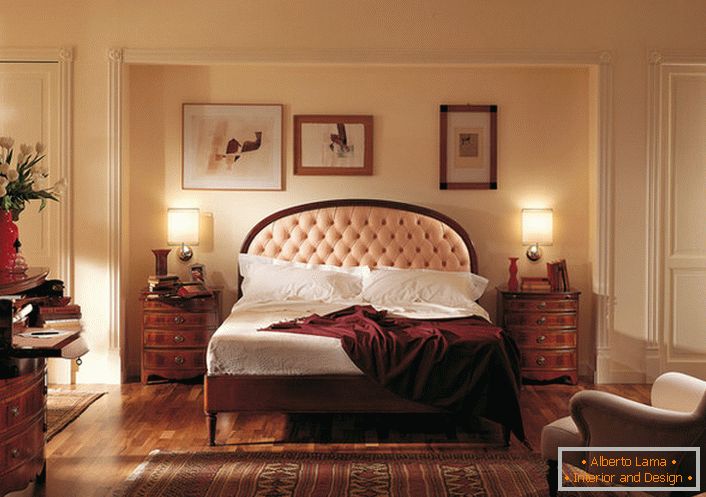El noble estilo inglés en el dormitorio es atractivo y modesto. El centro de atención es una cama en una cabecera alta, tachonada con un paño suave de color beige claro.