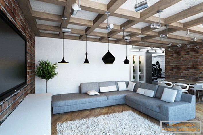 Acogedora y luminosa sala de estar en estilo loft. Armoniosa combinación de paredes de ladrillo de mampostería y vigas macizas. 