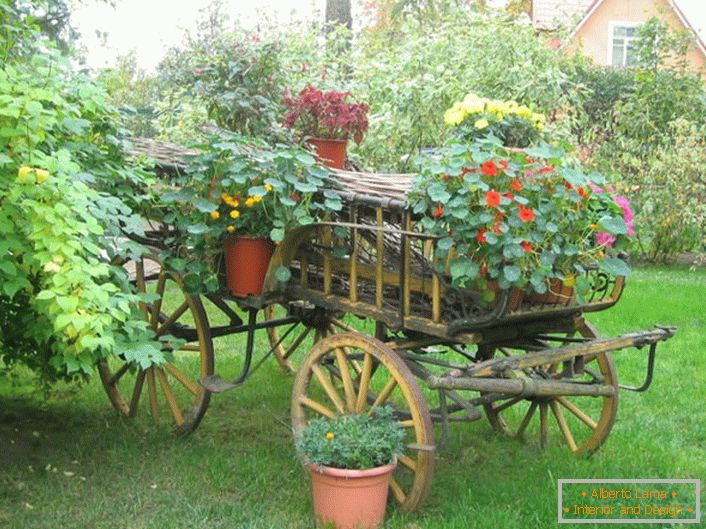 Los arriates de flores originales en estilo rústico se pueden hacer con un carrito viejo o una bicicleta innecesaria.