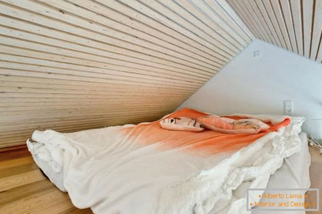 Dormitorio bajo el techo en una pequeña casa privada