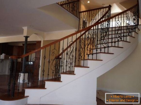 Una hermosa escalera de hormigón con rieles forjados en el interior de una casa privada
