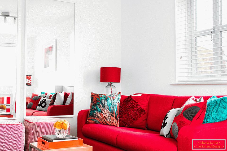 Muebles y accesorios rojos en la sala de estar blanca