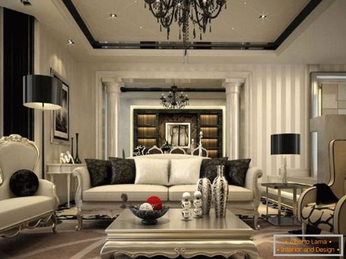 El exquisito interior de la sala de estar está pensado en estilo neoclásico. Los elementos negros de decoración y decoración son conspicuos contra el fondo de tonos grises desvaídos.