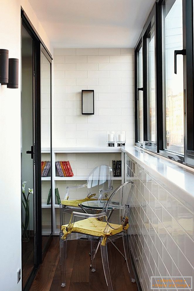 Sillas y mesa en un pequeño balcón, adornado con azulejos blancos