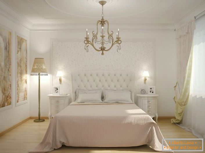 En el centro del interior del dormitorio hay una cama con una cabecera tapizada de tela alta. La tapicería suave y acolchada hace que la atmósfera sea noble y elegante.