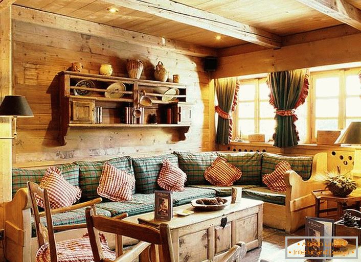Decoración de pared de madera, almohadas contrastantes en un sofá suave, cortinas densas con volantes en las ventanas. Acogedora sala de estar en un estilo rústico en una casa de campo.