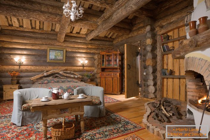 País rústico con un gran dormitorio de una casa de campo en Escandinavia. En cualquier interior, ejecutado en un estilo rústico, la chimenea se verá armoniosa, especialmente de un ladrillo. 