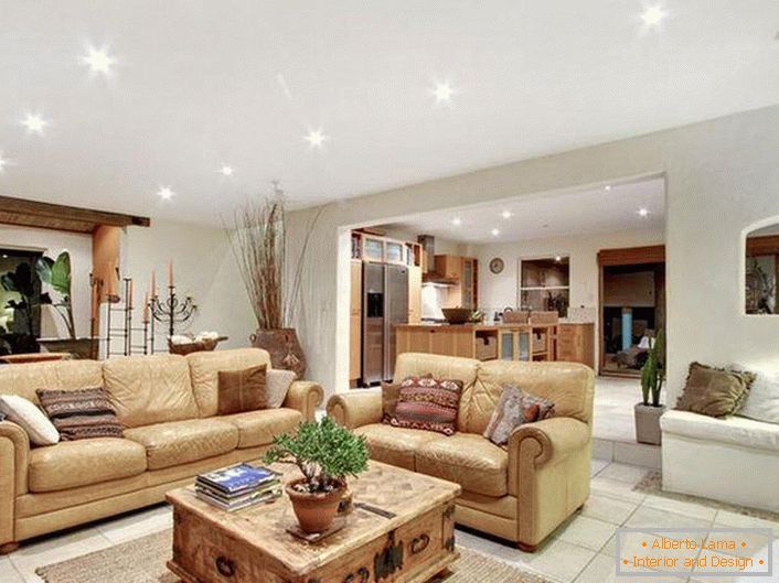 Lujoso y elegante interior de la sala de estar en el estilo mediterráneo. Muebles suaves, de color beige claro, iluminación correctamente seleccionada, suelo de baldosas: atestiguo el estilo mediterráneo.