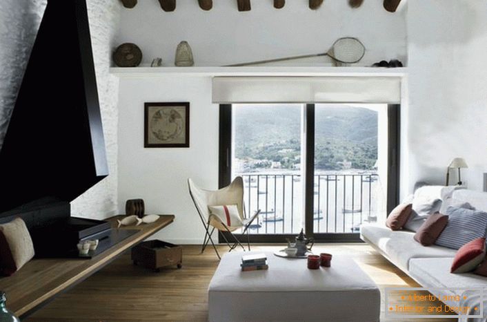El estilo mediterráneo implica un interior bien iluminado. Por lo tanto, las ventanas de la sala de estar no tienen cortinas ni cortinas gruesas.