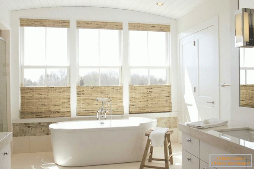 Baño caro con materiales naturales y ventanas grandes