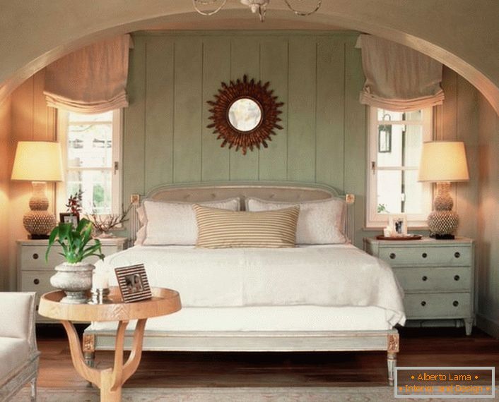Habitación familiar en estilo rústico. La calidez del hogar, de la mejor manera posible, se enfatiza con una cama suave y volumétrica, cubierta con almohadas.
