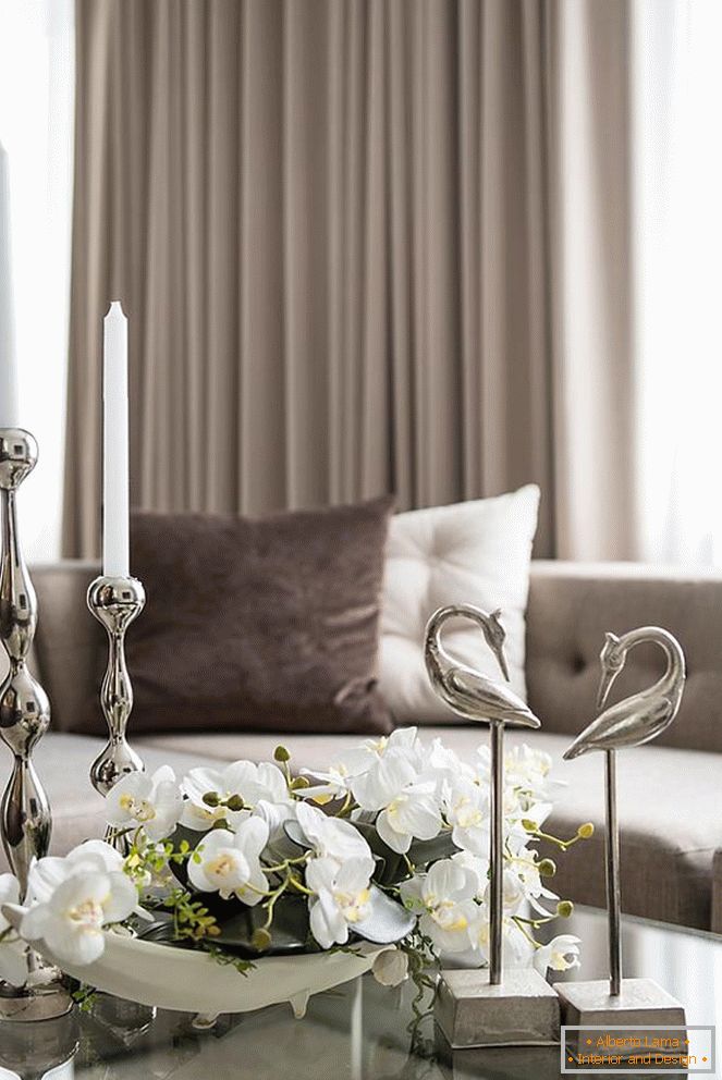 Composición de orquídeas, velas y otros elementos decorativos sobre la mesa en la sala de estar