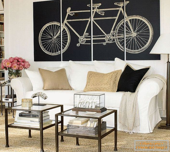 La sala de estar en el estilo escandinavo está decorada con pinturas modulares que representan una bicicleta. No sobrecargado de significado, el diseño completa el diseño. 