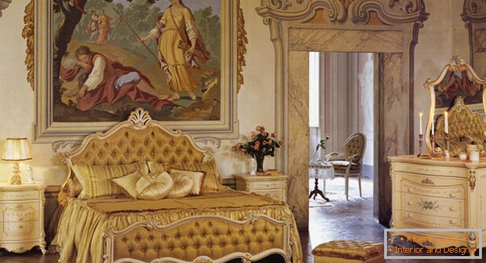 Dormitorio en estilo barroco en colores dorados. La pared en la cabecera de la cama está decorada con una enorme pintura antigua.
