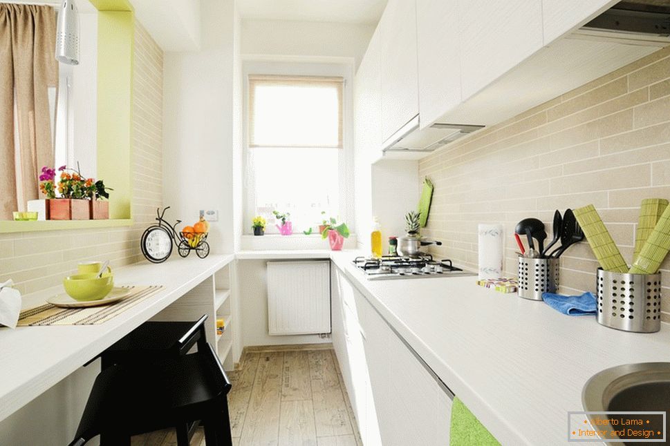 Cocina blanca larga con detalles en verde claro