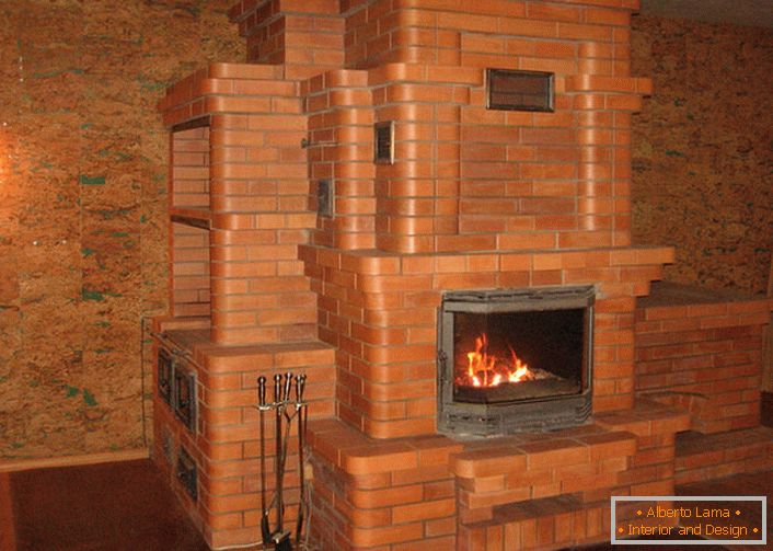 Una chimenea con horno de hierro fundido y un gran portal hecho de ladrillos calienta la casa durante mucho tiempo.
