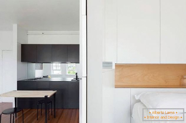 Pared modular en el interior del apartamento: una cocina negra y una habitación blanca como la nieve
